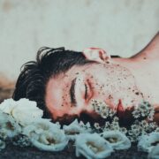 man lying on white flowers