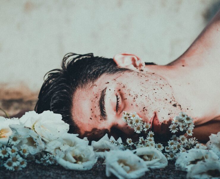man lying on white flowers