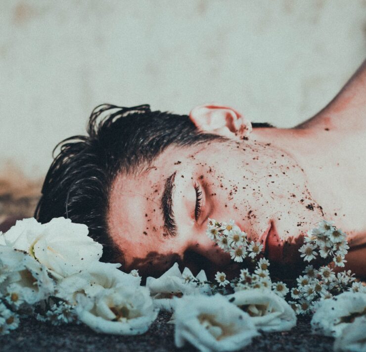 man lying on white flowers