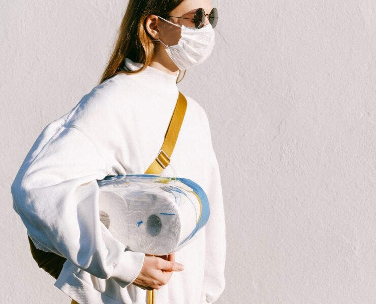 woman in mask holding toilet paper