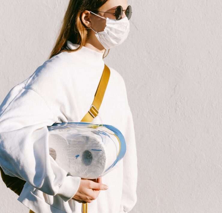 woman in mask holding toilet paper