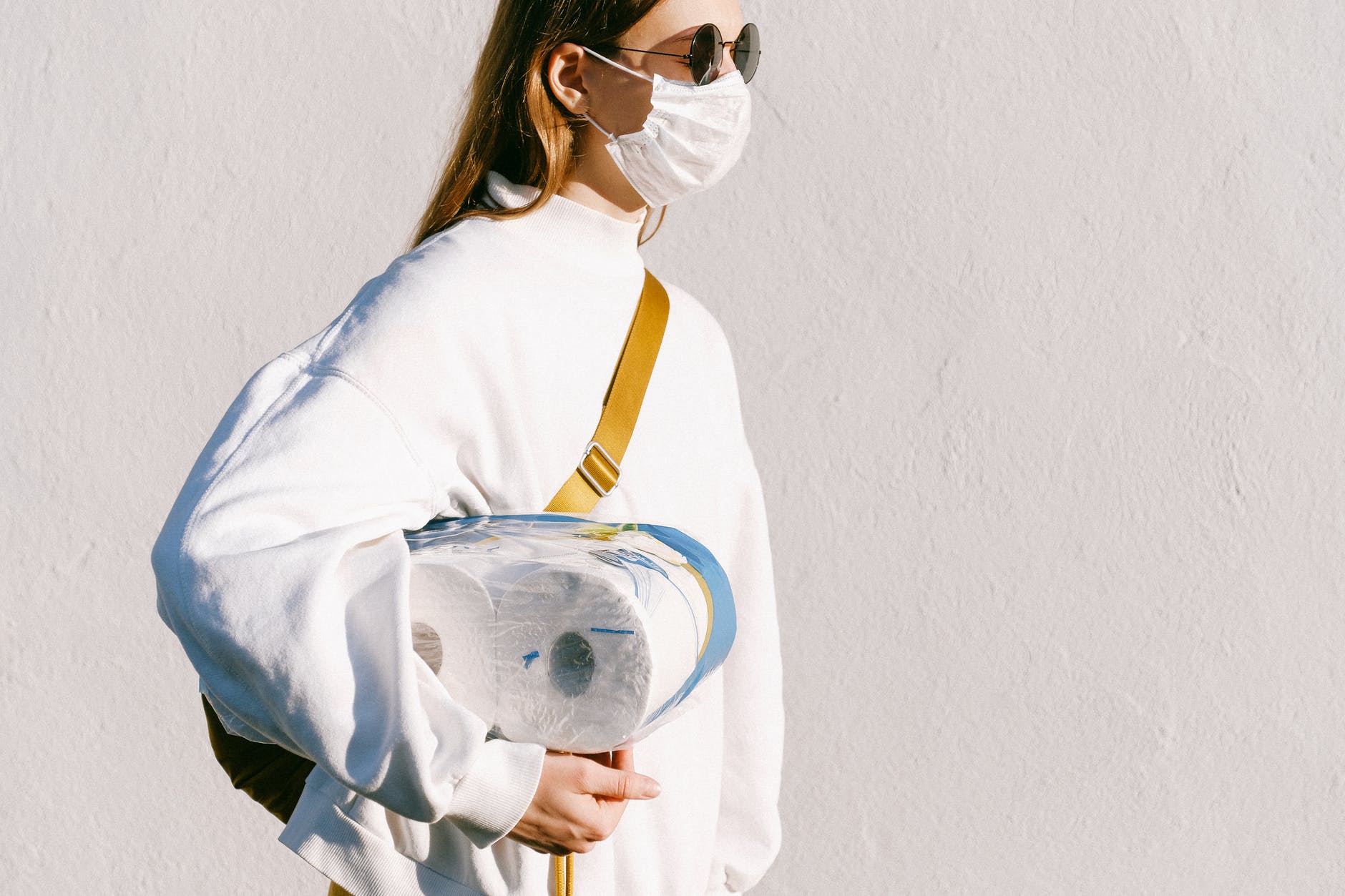 woman in mask holding toilet paper
