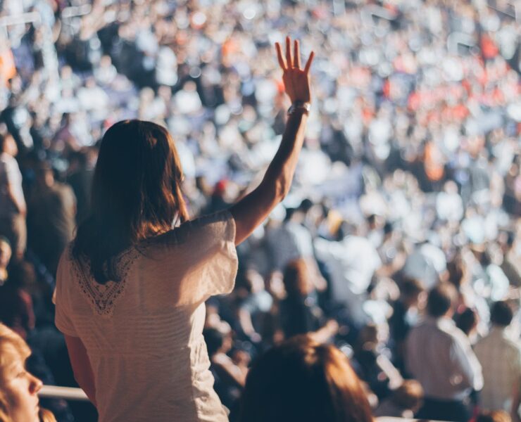 woman with white shirt raising her right hand
