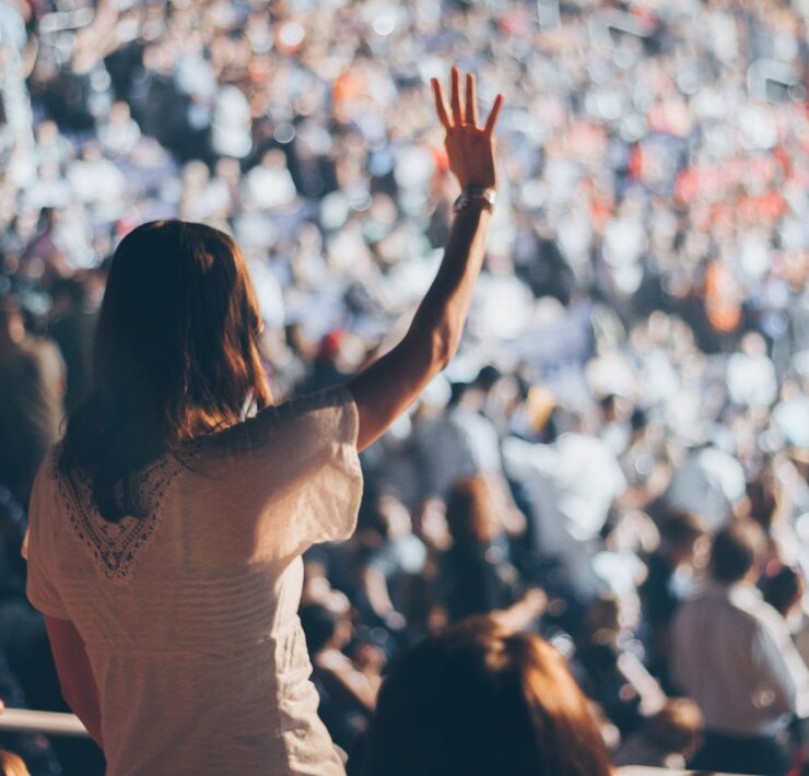 woman with white shirt raising her right hand