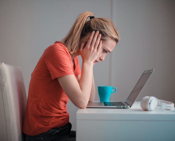 young troubled woman using laptop at home